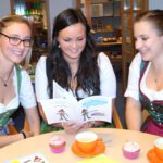 Rebecca Schneider, Bettina Hasenauer und Christina Hörfarter blättern im Rezepteheft