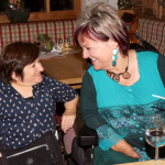 Lächelnde Frauen im Gespräch in einem gemütlichen Lokal, regionale Begegnungen in Österreich.