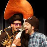 Musiker mit Saxophon und Mikrofon singen begeistert auf der Bühne in Lofer.