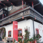 Traditionelles Holzgebäude mit Balkon, festlich geschmückt für die Kekserl-Aktion im Pinzgau.