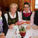 Vier Bäuerinnen in Tracht beim geselligen Beisammensein im Gasthof Schörhof.