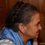 Frau mit geflochtenem Haar, Schal und lächelndem Gesicht im Gasthof Schörhof.