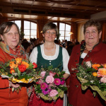 Drei Bäuerinnen mit Blumensträußen beim Jahrtag im Gasthof Schörhof in Saalfelden.