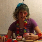 Faschingsteilnehmerin mit buntem Kostüm und Donuts in fröhlicher Atmosphäre.