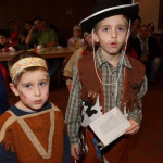 Zwei Kinder in fantasievollen Kostümen beim Kinderfasching im Pfarrsaal Saalfelden.