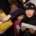 Kinder im Kostüm beim Fasching im Pfarrsaal, kreative Verkleidungen und Abstimmung.