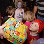 Kinder mit bunten Kostümen halten eine Sammelbox beim Kinderfasching in Saalfelden.