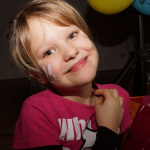 Fröhliches Kind mit Hasen-Gesichtsbemalung beim Kinderfasching im Pfarrsaal Saalfelden.