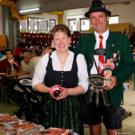 Traditionelle Trachtträger präsentieren regionale Produkte auf einem Fest in Lend.