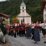Tanz und Musik beim Fest in Lend, umgeben von traditioneller Architektur und Natur.