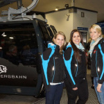 Drei Frauen in Sportjacken stehen vor der neuen Steinbergbahn in Leogang.